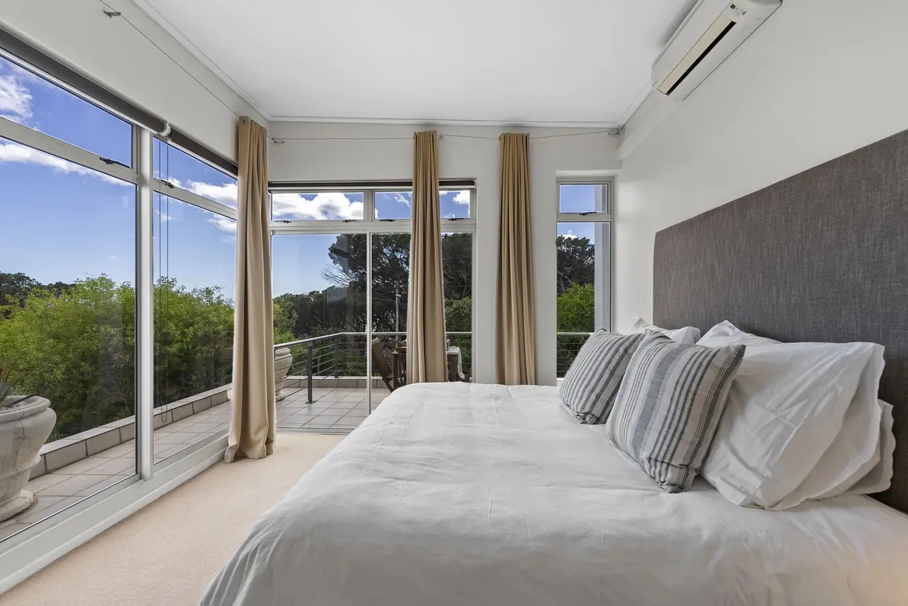 Main bedroom with a king bed and floor-to-ceiling windows onto the balcony, Camps Bay