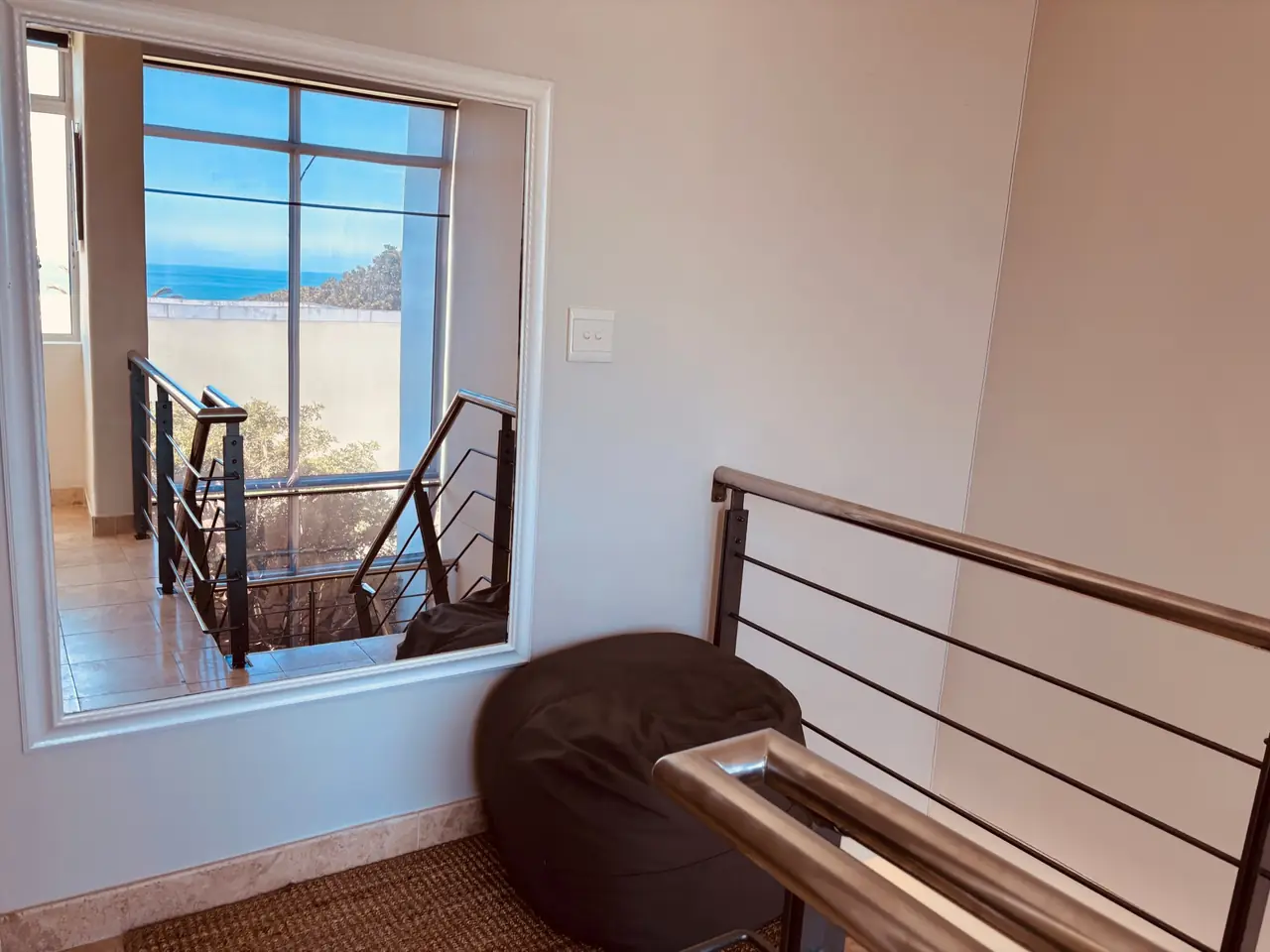 Chill zone on the landing: a bean bag, and a big mirror showing the sea through the stairwell window