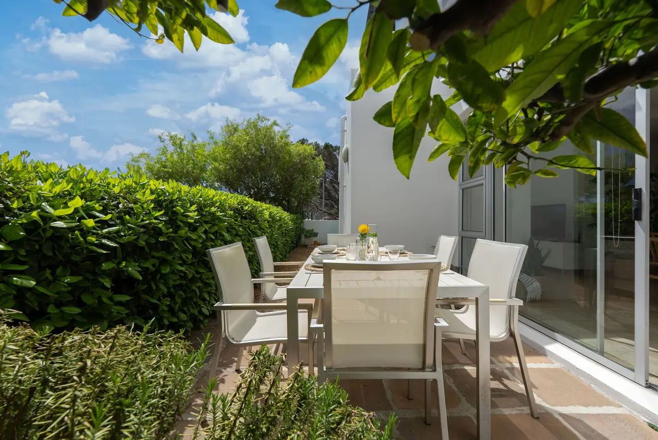 Outdoor table for six on the patio, under a lemon tree